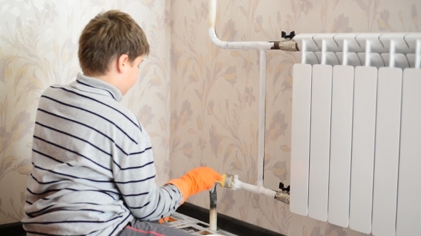 Boy Paints a Heating Radiator In  Apartment