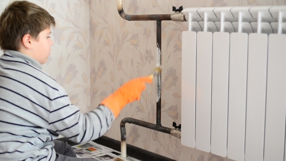 Boy Paints a Heating Radiator In  Apartment