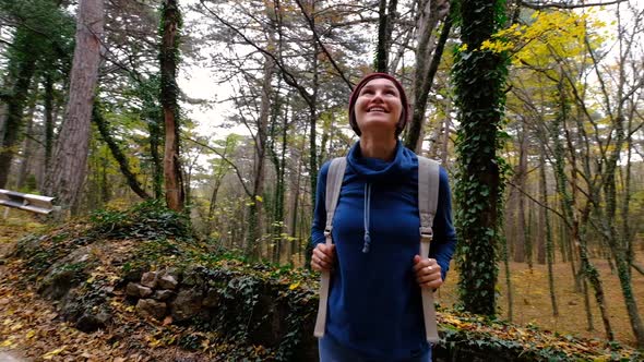 Young Woman Hiking in Forest in Autumn