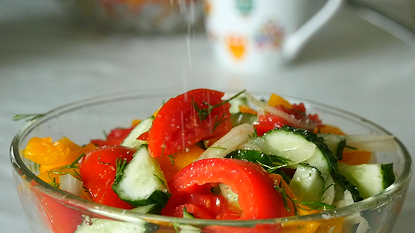 Hand Adding Salt Using Salt Shaker alt