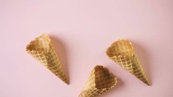 Empty waffle ice cream cones on a pink background.