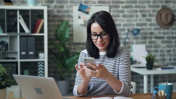 Beautiful Woman Using Smartphone Touching Screen Smiling in Office