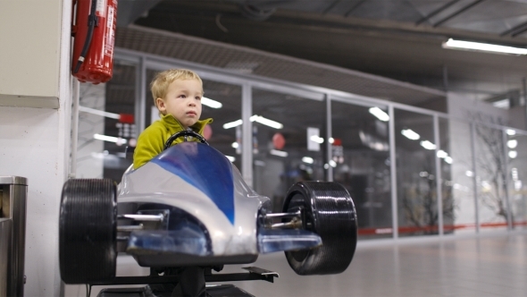 Little Boy Driving a Racing Car