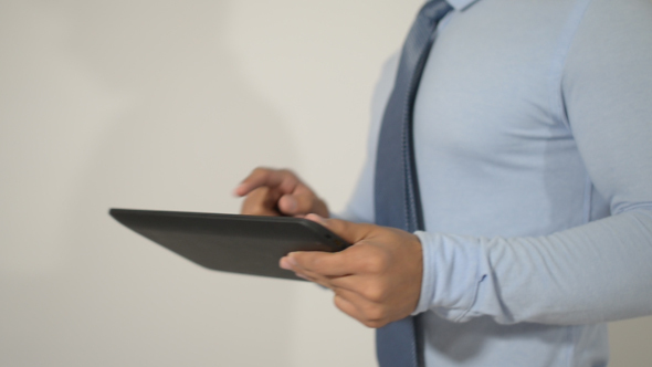 Businessman Using Tablet, while on Walk