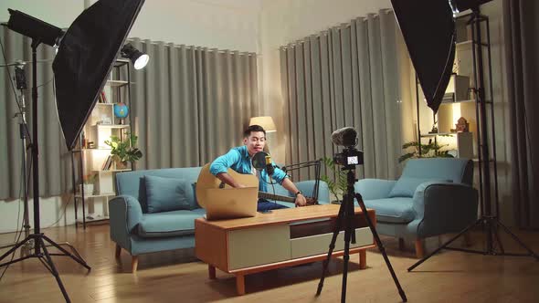 Asian Man Vlogger With Guitar Talking To Camera. Professional Light Equipment. Live Streaming