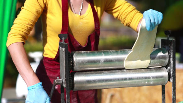 Woman Passes the Dough Through the Rollers
