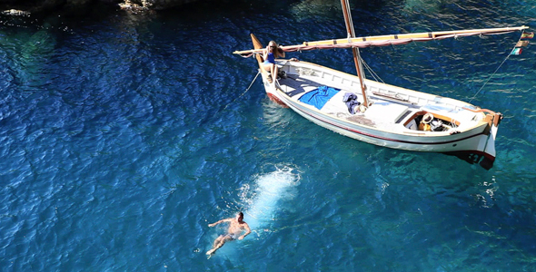 Couple Sunbathing On A Wooden Boat