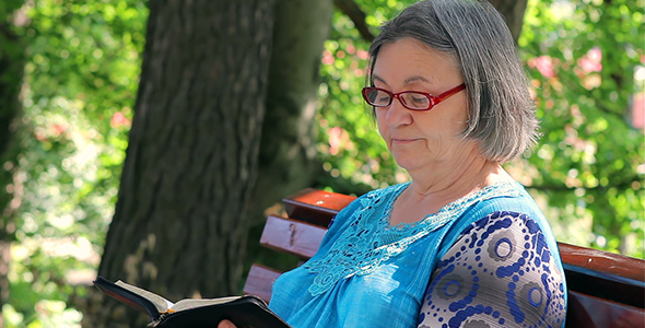 Elderly Woman Reading Bible Outdoors 