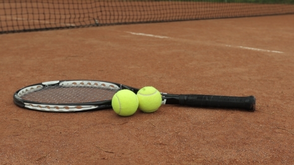 A Tennis Racket And New Tennis Ball On a Freshly