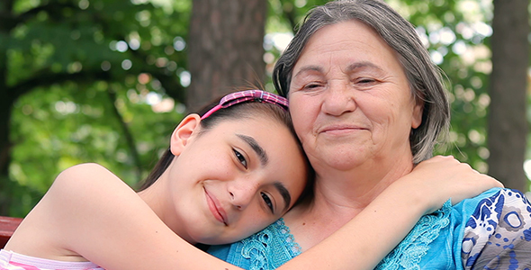 Granddaughter and Grandmother Smiling at Camera