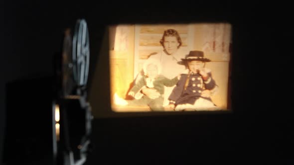 Old film projected onto wall of people in front of log cabins