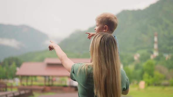 Mother and Little Boy Enjoy Valley with Mountain View
