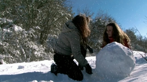 Mom And Daughter Playing In The Snow