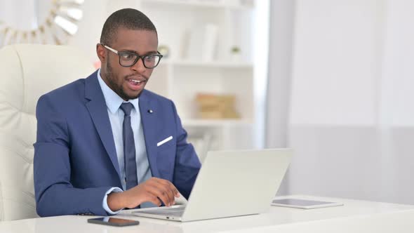 Winning African Businessman Celebrating Success on Laptop