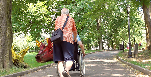 Senior Man Walking with Disabled Young Man