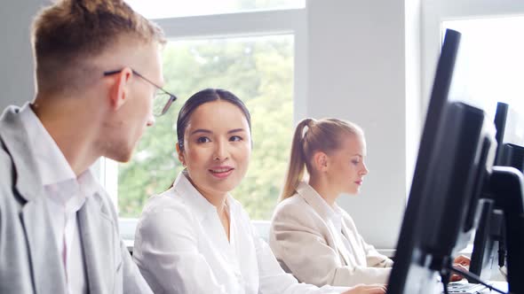 Diverse team of young professionals is working in the phone support office.