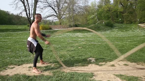 Trained Muscular Man Exercising With Ropes alt