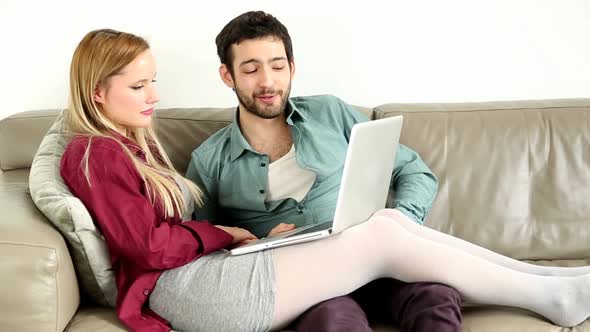 Young Couple Lounging On Couch With Laptop At Home 2