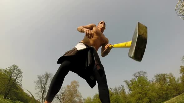 Close Up Of A Muscular Man Hitting With A Hammer, Changing Hands