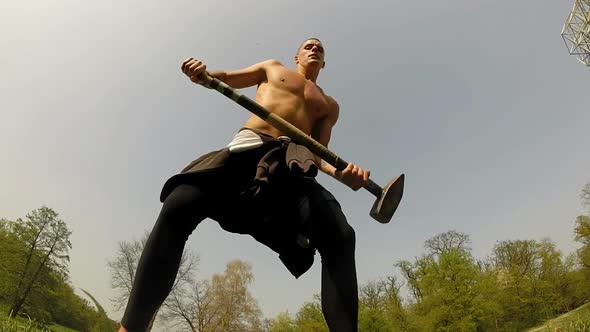 Close Up Of A Strong Man Hitting With A Hammer