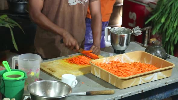 Close Up Of Chef Cutting Carrots In A Restaurant Kitchen In Weligama. alt