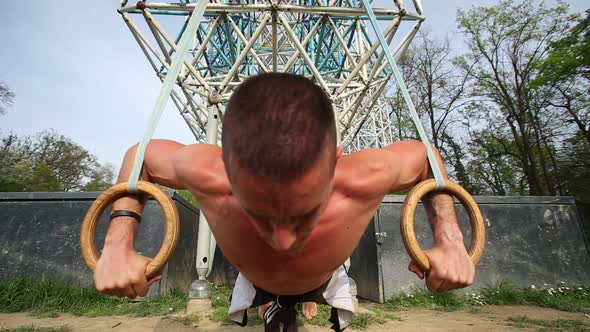 Close Up Of Muscular Man Doing Push Ups With Gymnastics Rings 1