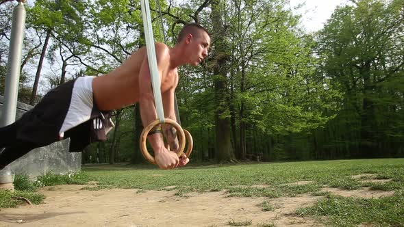 Close Up Of Muscular Man Doing Push Ups With Gymnastics Rings 3