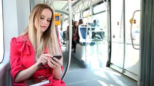 Beautiful Blond Woman Riding Tram, Typing On Mobile, Phone, Cell, Holding Glasses 1