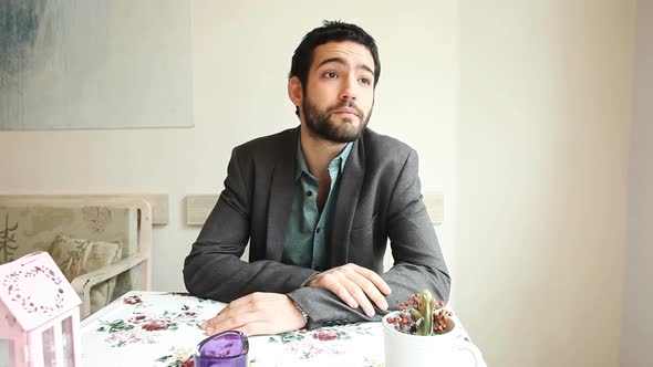 Handsome Young Man Waiting For His Date In A Cafe alt