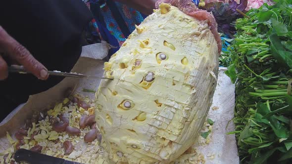 Hikkaduwa, Sri Lanka - March 2014: Woman Cutting Durian Fruit With Big Knife At Sunday Market 3 alt