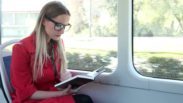 Beautiful Woman Riding Tram, While Reading Book 2 alt