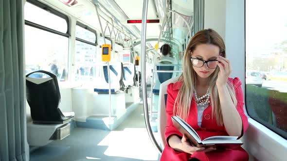 Beautiful Woman Riding Tram, While Reading Book 3