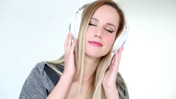 Beautiful Young Blond Woman Dancing With White Headphones 1