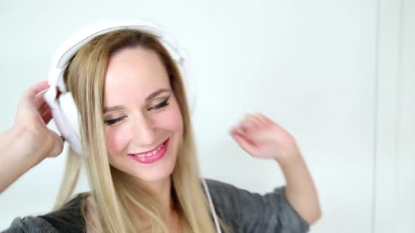 Beautiful Young Blond Woman Dancing With White Headphones 19