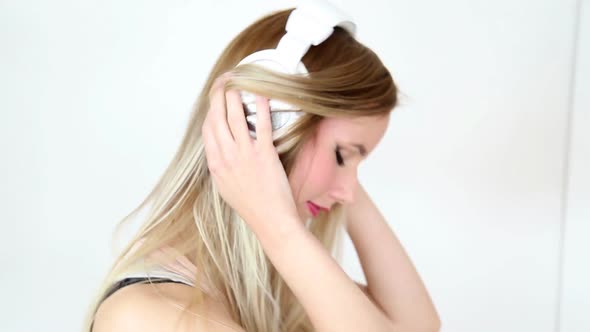 Beautiful Young Blond Woman Dancing With White Headphones 43