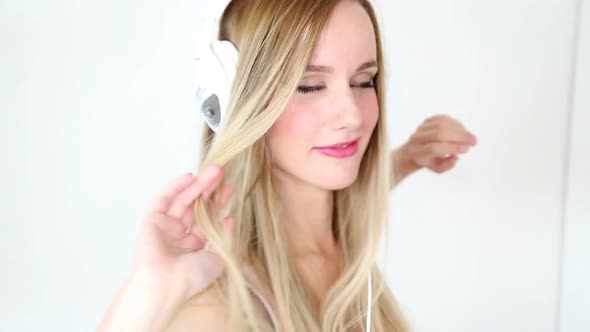 Beautiful Young Blond Woman Dancing With White Headphones 44