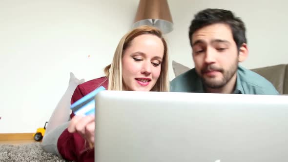 Woman And Man Lying On Carpet In Living Room And Buying Online 1