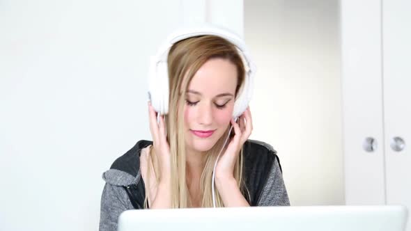 Beautiful Young Blond Woman Listening To Music On Laptop With White Headphones 10