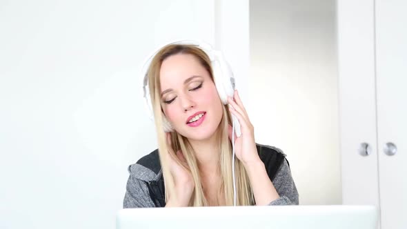 Beautiful Young Blond Woman Listening To Music On Laptop With White Headphones 12