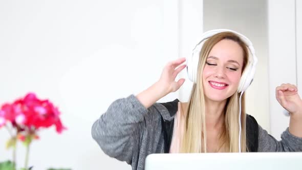 Beautiful Young Blond Woman Listening To Music On Laptop With White Headphones 13