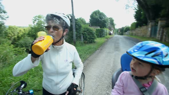 Woman Drinking From Water Bottle On A Cycling Tour In France