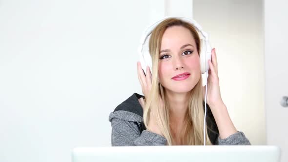 Beautiful Young Blond Woman Listening To Music On Laptop With White Headphones 9