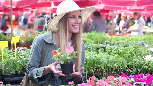 Blonde Beautiful Woman Holding Flower In The Market 1