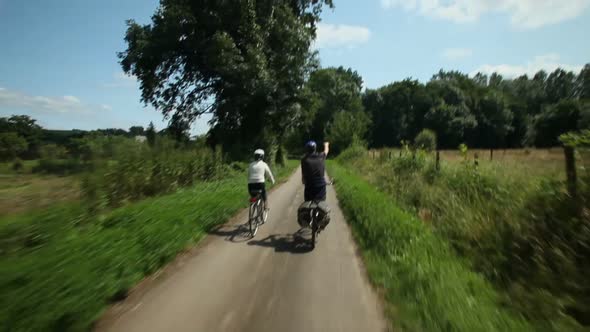 Slow Motion - Retired Couple Cycling On Road In Village In France 1