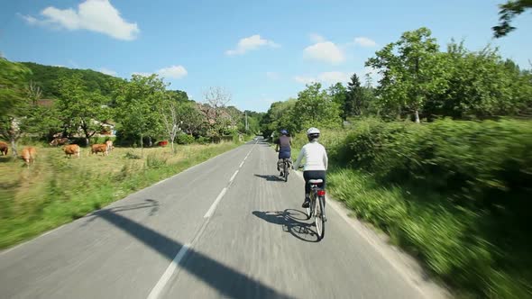 Slow Motion - Retired Couple Cycling On Road In Village In France 6 alt