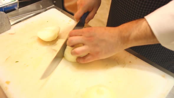 Chef Slicing Onions In Kitchen 1