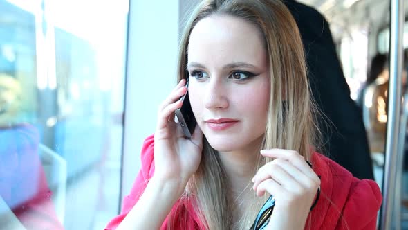 Young Blond Woman Riding Tram, Talking On Mobile, Phone, Cell And Playing With Hair 2 alt
