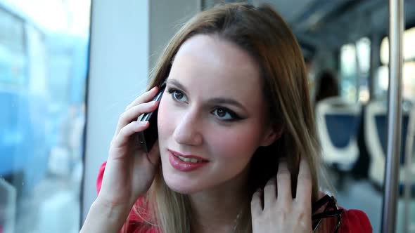 Young Blond Woman Riding Tram, Talking On Mobile, Phone, Cell, Holding Glasses alt