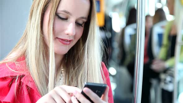 Young Blond Woman Riding Tram, Typing On Mobile, Phone, Cell