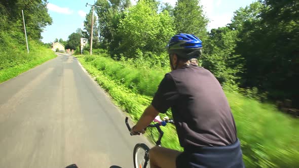 Man Cycling On Road In Countryside